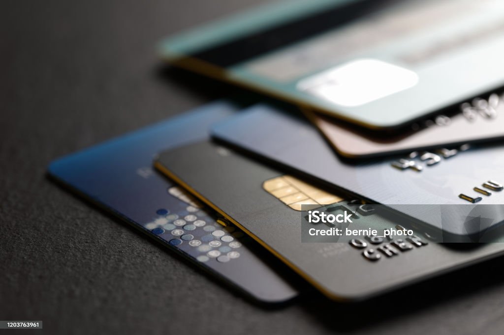 stack of multicolored credit cards on black background